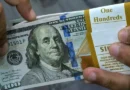 Dólar cai e Bolsa recua pressionada por balanços do varejo